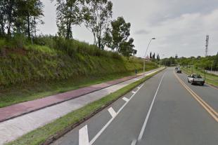 #PraCegoVer: Foto mostra calçada e ciclovia em trecho da Rodovia Visconde de Porto Seguro. Uma pessoa corre na ciclovia e carros trafegam em uma das faixas. 