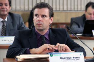 #PraCegoVer: Foto do vereador Rodrigo Toloi sentado em sua mesa, acompanhando a sessão ordinária.