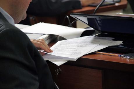 #PraCegoVer: Foto mostra a mão de um vereador folheando um documento
