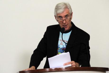 #PraCegoVer: Foto do vereador Mayr na tribuna da Câmara, discursando para os demais vereadores e para o público. Ele usa por baixo do terno uma camiseta alusiva ao Dia Mundial da Conscientização do Autismo.