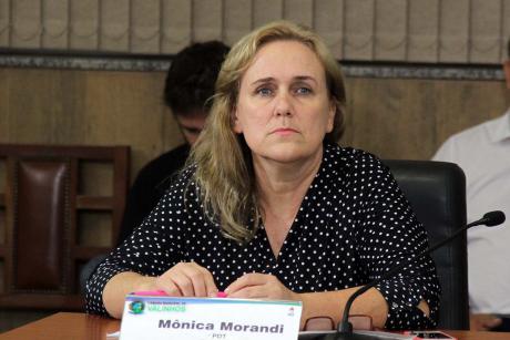 #PraCegoVer: Foto mostra a vereadora Mônica Morandi (PDT) sentada em seu lugar no plenário, prestando atenção na sessão ordinária.