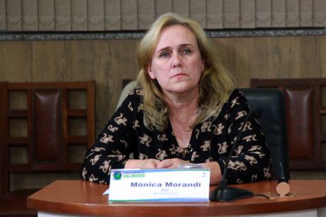 #PraCegoVer: Vereadora Mônica Morandi presta atenção na sessão sentada em sua tribuna no plenário da Câmara