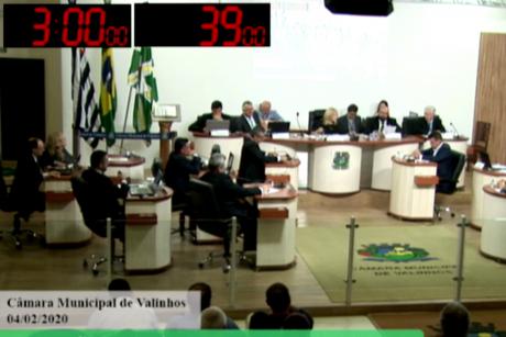 #PraCegoVer: Foto mostra a tela da TV Câmara com os vereadores no plenário e dois cronômetros no canto superior esquerdo. 