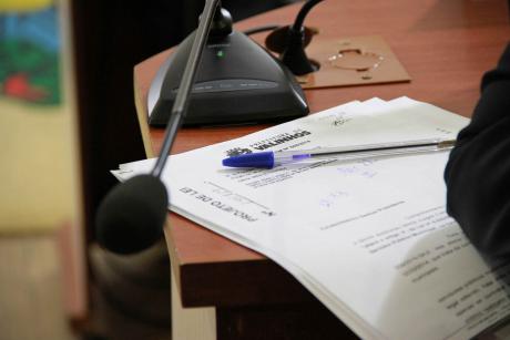 #PraCegoVer: Foto mostra documentos em cima da mesa de um vereador. Na mesa também há o microfone usado pelo parlamentar e uma caneta.