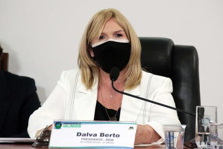 #PraCegoVer: Vereadora Dalva Berto fala ao microfone durante a sessão sentada à mesa diretora. Ela usa uma máscara. 