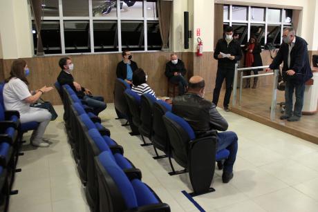 #PraCegoVer: Foto mostra reunião de dois vereadores, que estão em pé, com seis cidadãos sentados com espaçamento social nas poltronas do plenário da Câmara. 