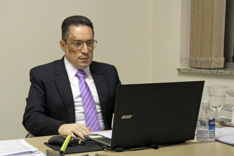 #PraCegoVer: Fábio Damasceno acompanha a sessão a partir de um computador portátil em sua mesa
