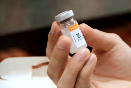 #PraCegoVer: Foto mostra mão segurando um frasco da vacina Coronavac.