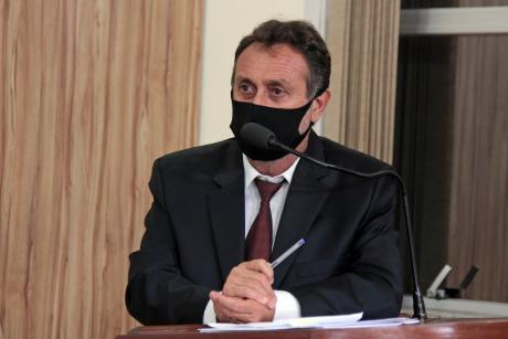#PraCegoVer: Vereador Edinho Garcia discursa ao microfone na tribuna da Câmara. Ele usa uma máscara preta e segura uma caneta.  