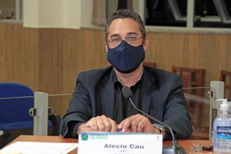 #PraCegoVer: Alécio Cau acompanha a sessão de sua tribuna na Câmara. Ele usa máscara e tem um dispensador de álcool gel à mesa. 
