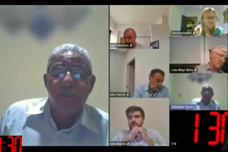 #PraCegoVer: Imagem da tela de videoconferência mostra momento em que o vereador Tunico fala durante a sessão virtual. O rosto dele ocupa metade da tela; a outra metade é ocupada pelos rostos de outros vereadores.