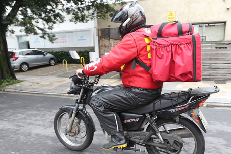 #PraCegoVer: foto mostra motoboy pilotando a moto durante entrega