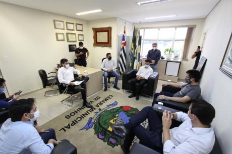 #PraCegoVer: Foto mostra o presidente Franklin e o vereador Gabriel Bueno conversando com os parlamentares de Brasília e São Paulo, no gabinete da presidência. Todos estão sentados.