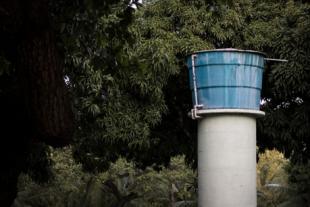 #PraCegoVer: Foto mostra caixa d'água em cima de uma estrutura de concreto.