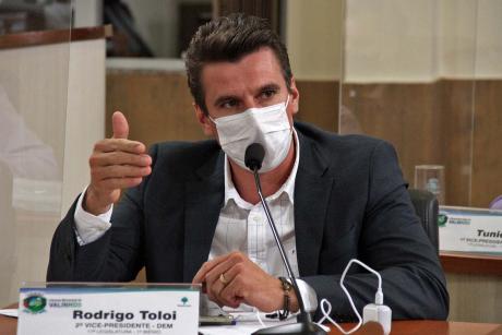 #PraCegoVer: Foto mostra o vereador Rodrigo Toloi sentado em seu lugar no plenário, discursando durante a sessão.