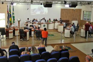 #PraCegoVer: Foto mostra o plenário visto de cima, com os vereadores sentados em seus lugares. Também é possível ver parte do público que acompanha a sessão.