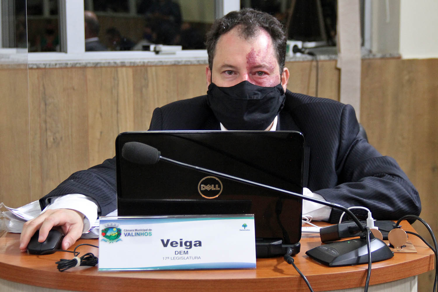 #PraCegoVer: Foto mostra o vereador Veiga acompanhando a sessão, sentado em seu lugar. Ele mexe em um notebook.
