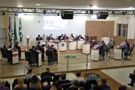 #PraCegoVer: foto mostra o plenário visto de cima com os vereadores sentados em seus lugares. É possível ver parte do público que acompanha a sessão.