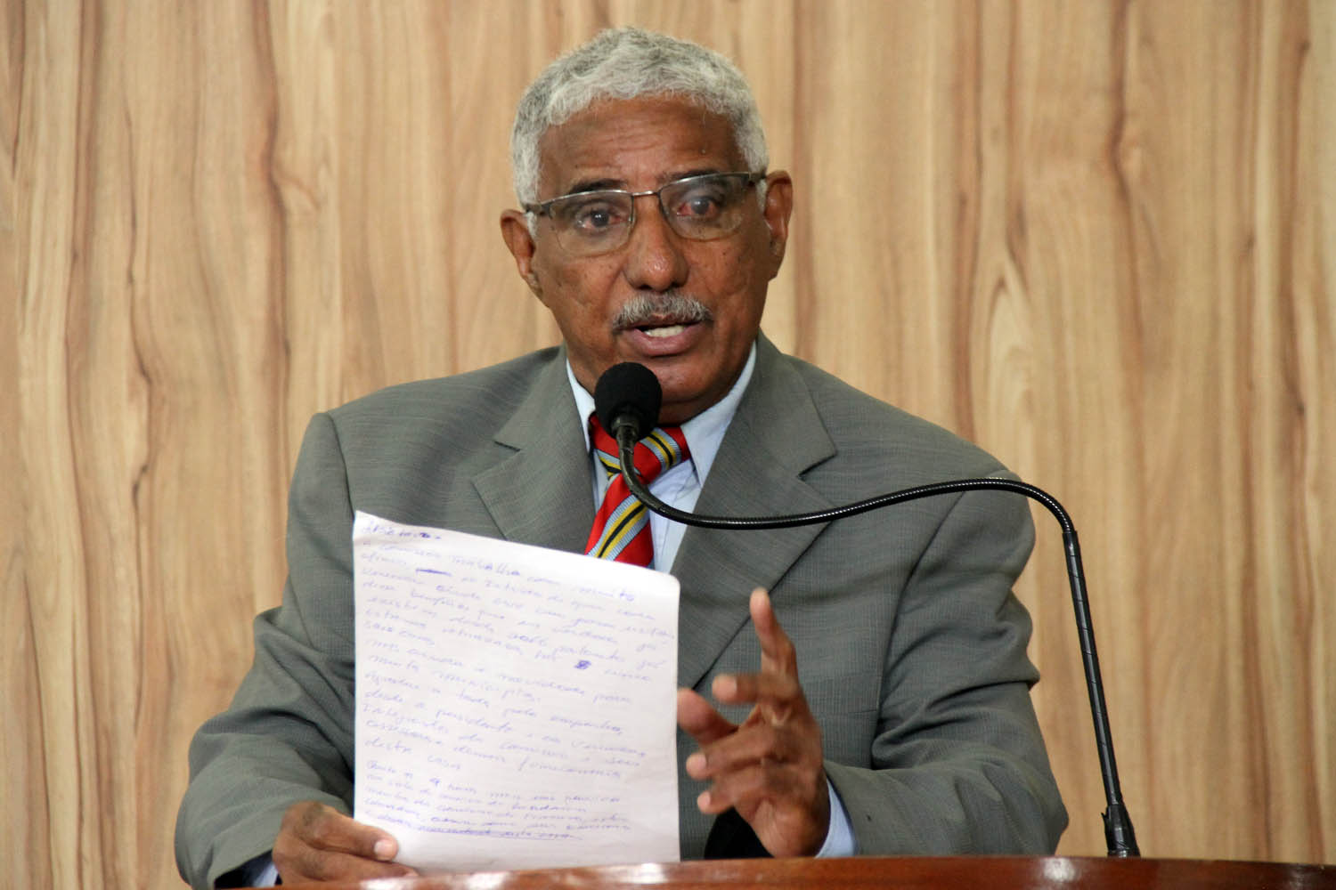 #PraCegoVer: foto mostra o vereador Tunico discursando na tribuna da Câmara. Ele segura um documento com várias anotações nas mãos.