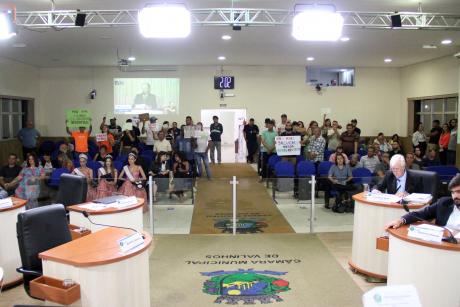 #PraCegoVer: Foto mostra o público que acompanha a sessão. É possível ver cartazes com dizeres contra o projeto de lei do Plano Diretor.